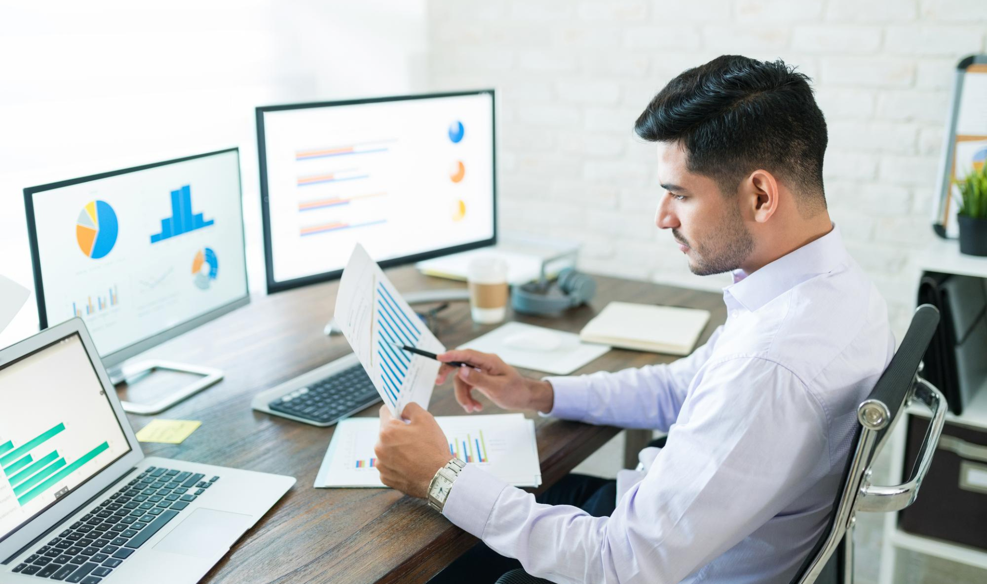 SEO analyst reviewing performance metrics on multiple monitors with charts and graphs.