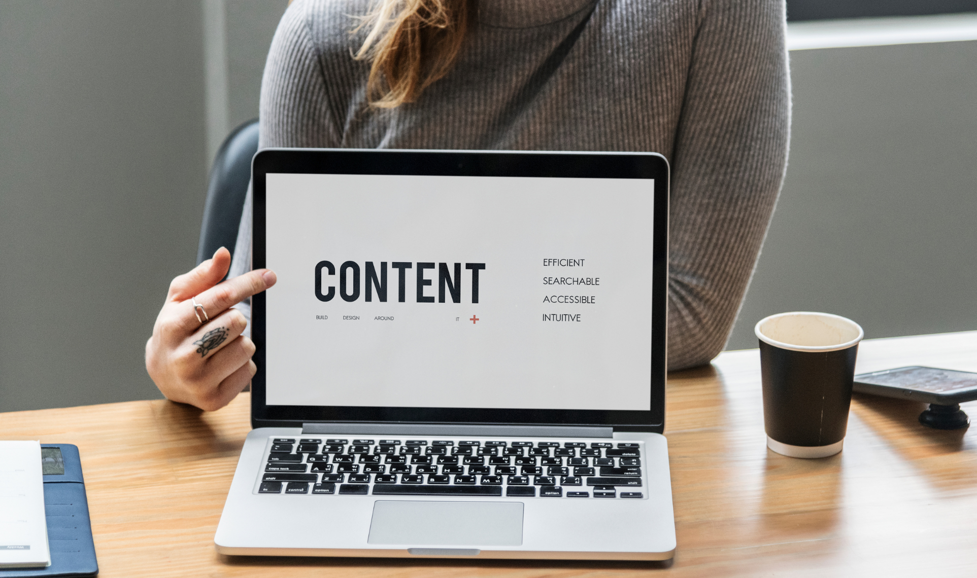Person pointing at a laptop screen displaying the word CONTENT, focusing on effective Website content.