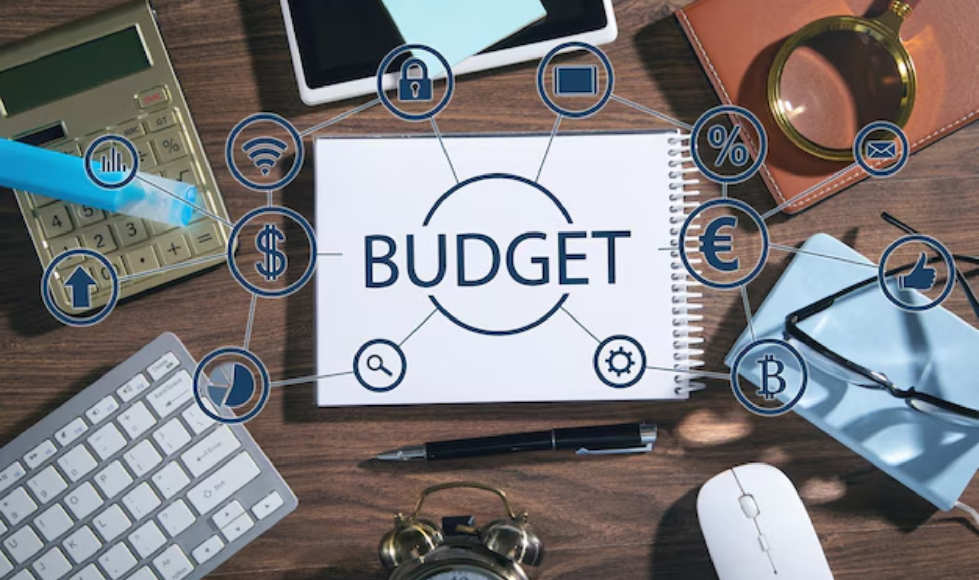 Overhead view of a notebook reading 'BUDGET' surrounded by business icons, symbolizing Flexible Budgets and financial planning.